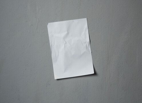 Empty old wrinkled white A4 paper stick on gray cement wall, changeable background. white paper note on gray © showcake