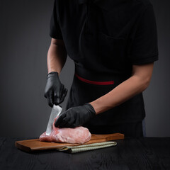 Cooking,Man chef cuts with knife fresh beef or pork