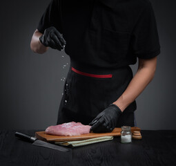 Cooking,chef sprinkles sea salt on fresh beef or pork