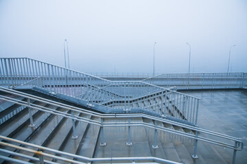 Fototapeta premium Embankment and city road near the river in heavy fog