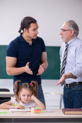 Young parent, old male teacher and little girl in the classroom