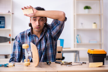 Young man repairing skateboard at workshop