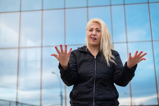 Emotional deaf and dumb woman talking sign language outdoors.