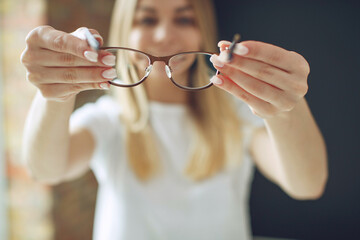 A woman has vision problems, squints when trying to see something, takes off her glasses, is...