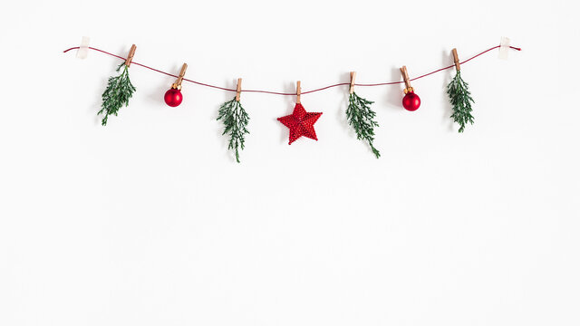 Christmas composition. Garland made of red balls and fir tree branches on white background. Christmas, winter, new year concept. Flat lay, top view