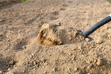 the shovel digs the ground, the soil falls down