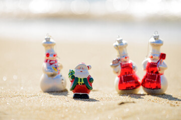 New Year and Summer travel. Snow man and Santa on sea beach. Christmas and vacation.