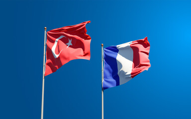 Beautiful national state flags of France and Turkey together at the sky background. 3D artwork concept.