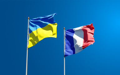 Beautiful national state flags of France and Ukraine together at the sky background. 3D artwork concept.