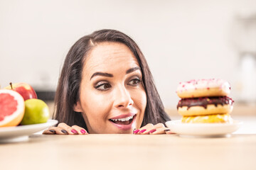 Girl preferring plateful of donuts instead of a plate with fresh fruit