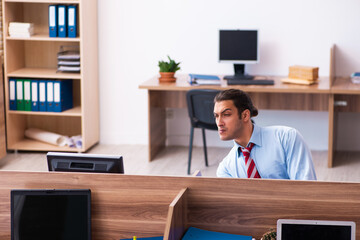 Young male employee in industrial espionage concept