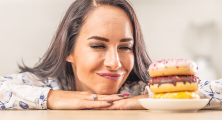 Woman passionately looking forward to eat a pile of doughnuts