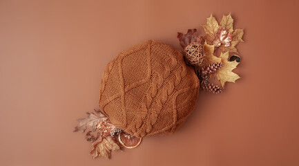 Autumn composition with round knitted element on brown background top view.