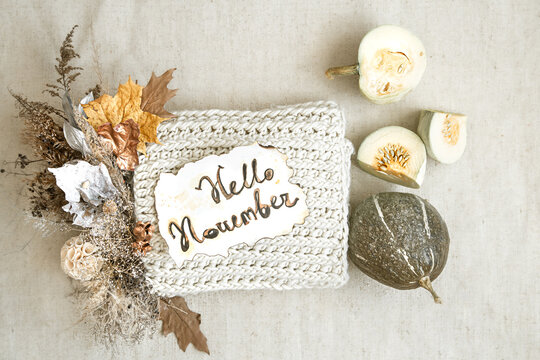 Still life Hello Nowember with bouquet, pumpkin and knitted element on a white background top view.