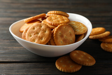 Bowl with tasty cracker biscuits on wooden background
