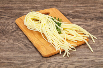 Chechil spaghetti cheese over board