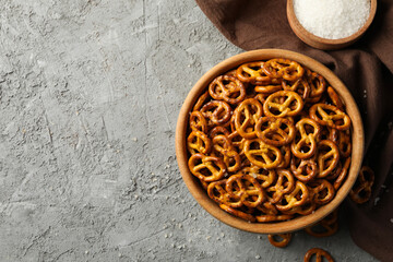 Napkin and bowl with cracker pretzels on gray background