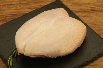 Raw whole chicken breast with skin