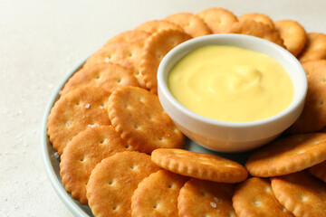Napkin and plate with cracker biscuits and cheese sauce on white - light beige background