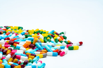 Fototapeta na wymiar Selective focus on pile of multi-colored antibiotic capsule pills. Antimicrobial capsule pills on white background. Antibiotic resistance concept. Pharmacy drugstore products. Pharmaceutical industry.