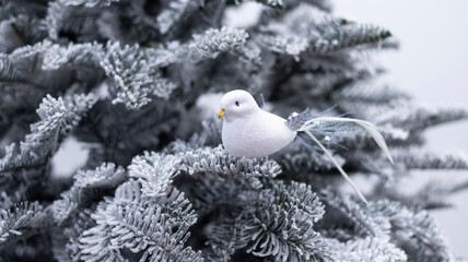 Christmas ball snow-covered fir tree, close-up, blurred bokeh background. Christmas background for a postcard. Decoration for a Christmas tree, spruce branches, New Year's toys.