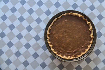 Delicious pumpkin pie with ground cinnamon, nutmeg and ginger on the table. Pie cooked by man. Traditional dessert for Thanksgiving. Copy space. Patterned background. Top view. Dublin, Ireland