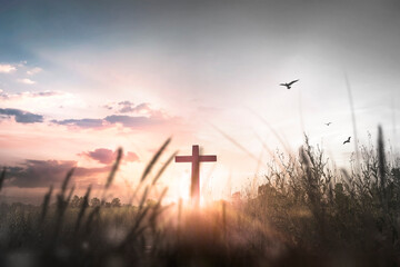 Easter concept: Silhouette cross on mountain at sunset background