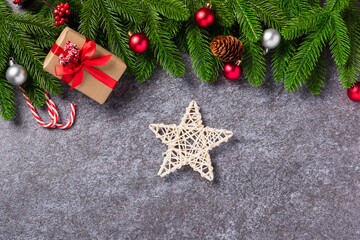 Christmas background. Top view border green pine cones fir tree branches with Xmas decoration, gift box and the star on concrete table background with copy space for text, Happy new year day concept