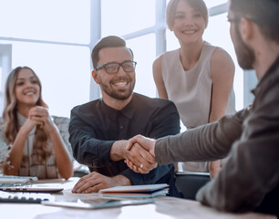 background image of the handshake of business partners in the office