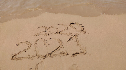 inscription 2020  2021 on beach sand