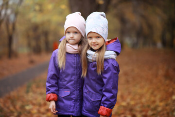 Young family on a walk in the autumn park on a sunny day. Happiness to be together.