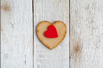 Red and wooden hearts on an old white background