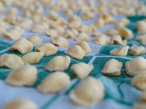 Dinner time at home with the family. On a tablecloth numerous orecchiette, a typical product of southern Italian cuisine.