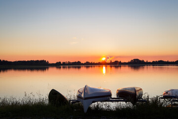 Naklejka na ściany i meble Rowing boats on the lake shore in the sunset