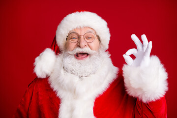 Close up photo of positive santa claus show okay sign x-mas tradition season discounts wear red costume white gloves isolated bright shine color background