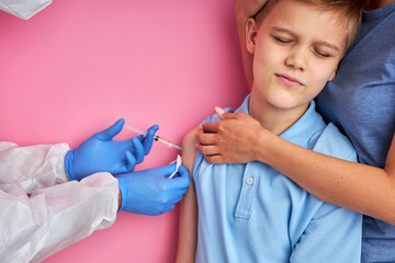 male doctor giving vaccine shot to frightened child boy, kid is afraid of injections. prevention, protection and immunization concept