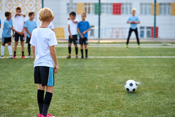 Obraz premium kids boys training with ball before sport competition, they are preparing for match in stadium, 8-9 years old children in unifrom