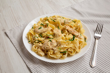 Homemade Chicken Fettuccine Alfredo on a white plate, low angle view.