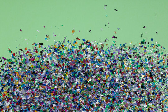 Recycled Plastic Soup Pellets Collected From The Sea Water, Flatlay On A  Green Background. Colorful Pieces And Textures. Rethinking The Environment By Reducing Or Reusing Plastics. Circular Economy