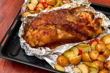 baked meat and potatoes on a baking sheet, pork knuckle delicious food