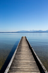 Fototapeta na wymiar travel germany and bavaria, view above a lake with landing stage and mountain view, Chiemsee, Bavaria, Germany