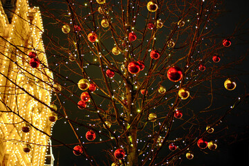 Yellow and red Christmas balls on a tree as an element of decorating city streets for the New Year