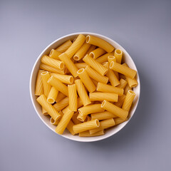 tortiglioni pasta in a plate, on a gray background close-up, isolated