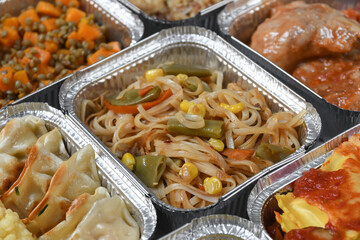 Different aluminium lunch box with with takeout coronavirus food.  Food delivery covid-19 takeaway 