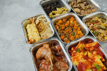 Different aluminium lunch box with with takeout coronavirus food.  Food delivery covid-19 takeaway 