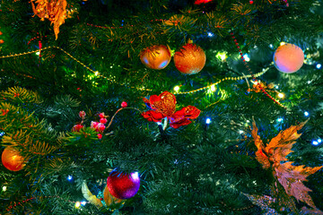 Branches of a green Christmas tree decorated with mistletoe and balls before the new year