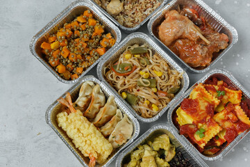 Different aluminium lunch box with with takeout coronavirus food.  Food delivery covid-19 takeaway 
