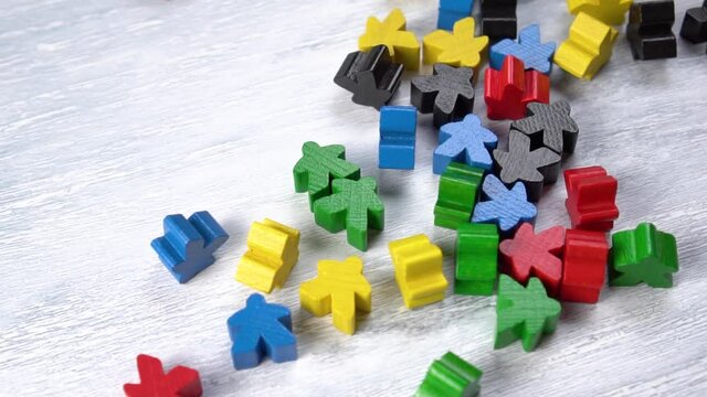 Bright colored wooden toy figures on a plank closeup. Rotation