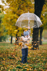 child with umbrella in autumn forest