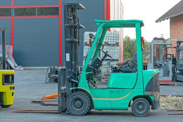 Green Forklift Truck in Front of Warehouse